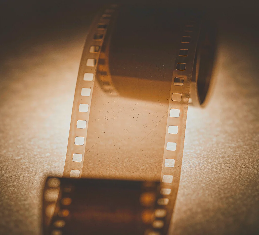 Macro photograph of a blank 35mm film strip backlit on an amber lightbox